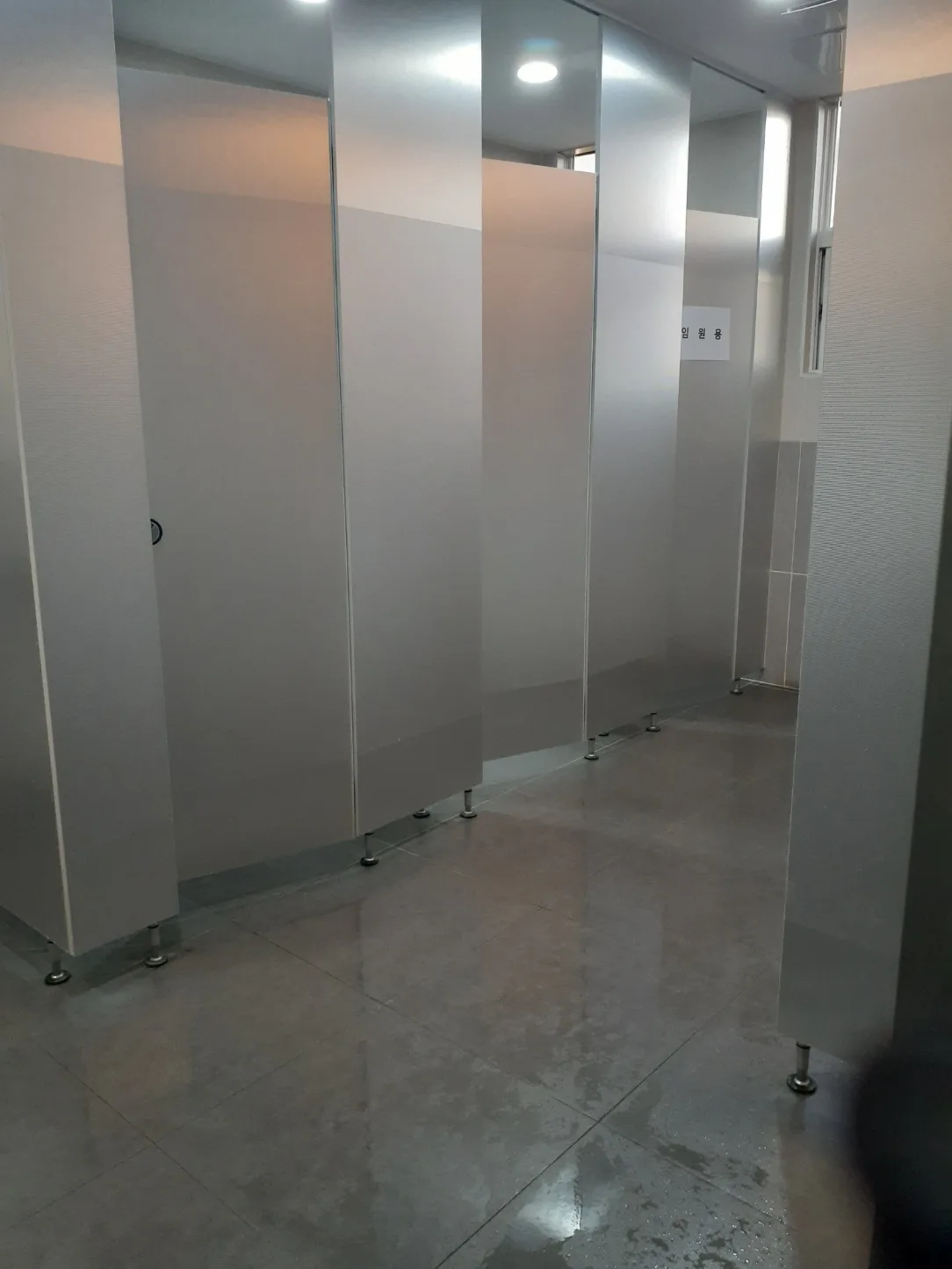 여러 칸으로 나뉜 화장실의 칸막이와 바닥을 물청소한 실제 작업사진